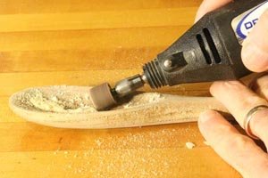 Using a Dremel to sand the bowl of the wooden spoon.